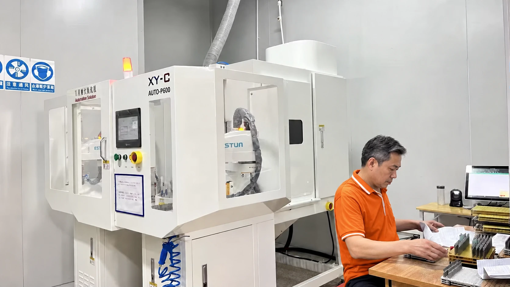 An operator beside enclosed tool honing equipment — reference image for Solid Carbide Ball Nose End Mills