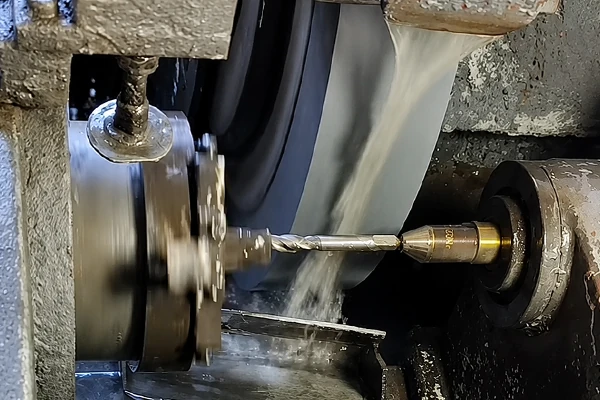 Supported cutting tool beside a wheel with coolant