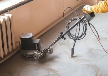 Operario y máquina de desbaste sobre un suelo de hormigón